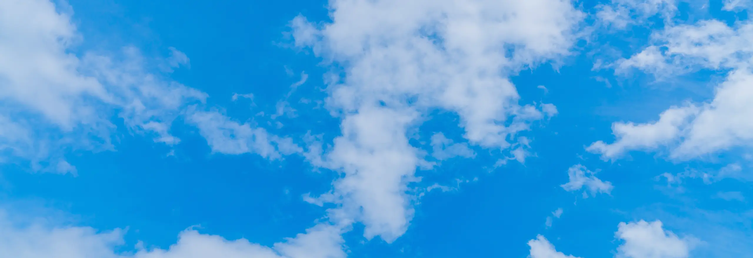 Céu azul com nuvens suaves — transmitindo leveza, abertura e proximidade, convidando o visitante a entrar em contato com a equipe da Volare.